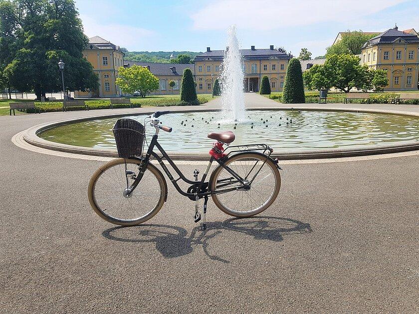 Ein Fahrrad vor einem Brunnen in einer Parkanlage