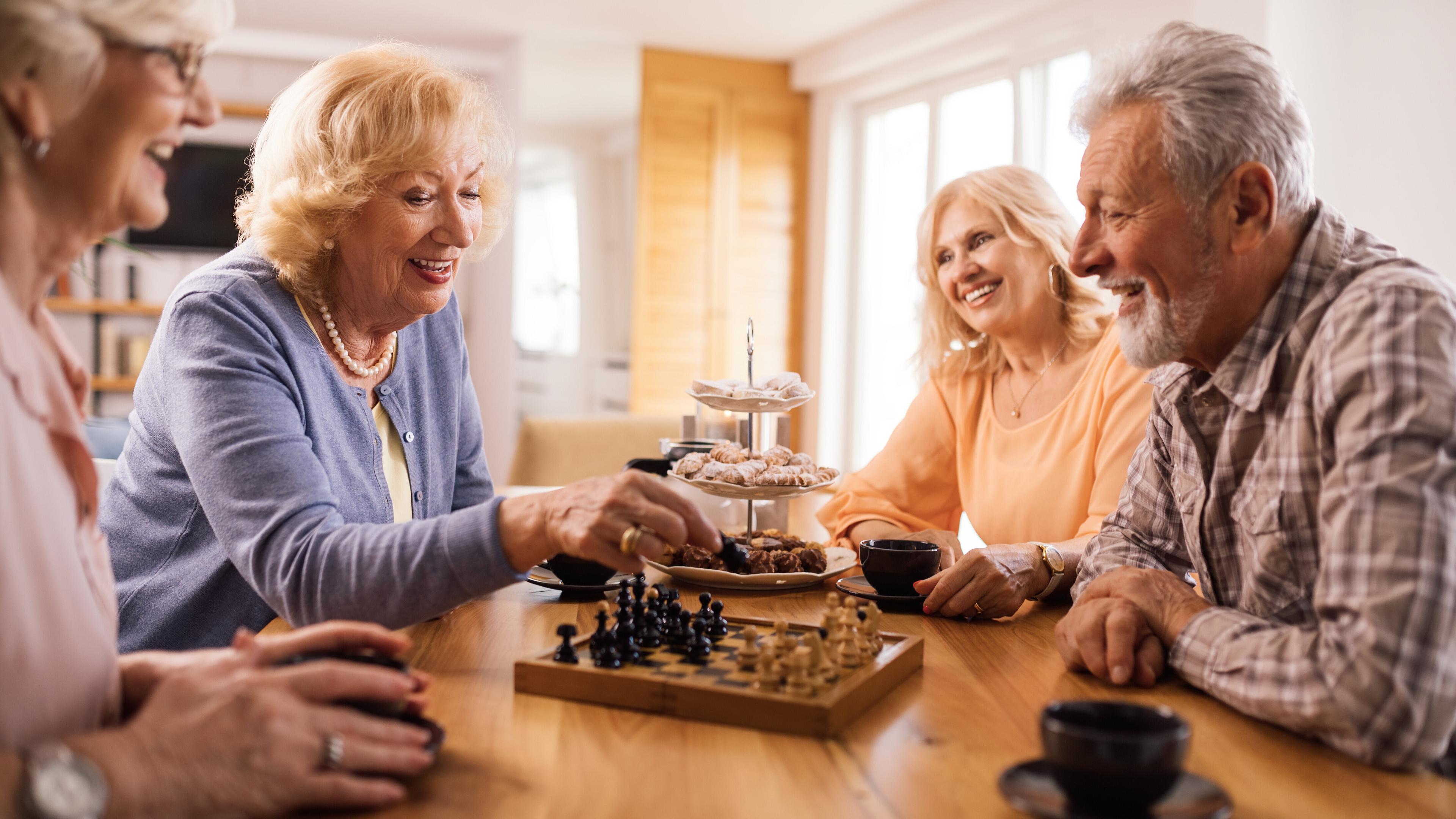 4 Senioren spielen ein Brettspiel
