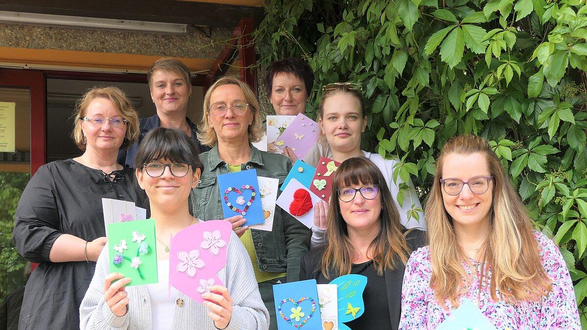 Die Schülerinnen Mariola Nonichef und Chantal May überreichen die selbst gestalteten 18 Postkarten an AGATHE Gera.