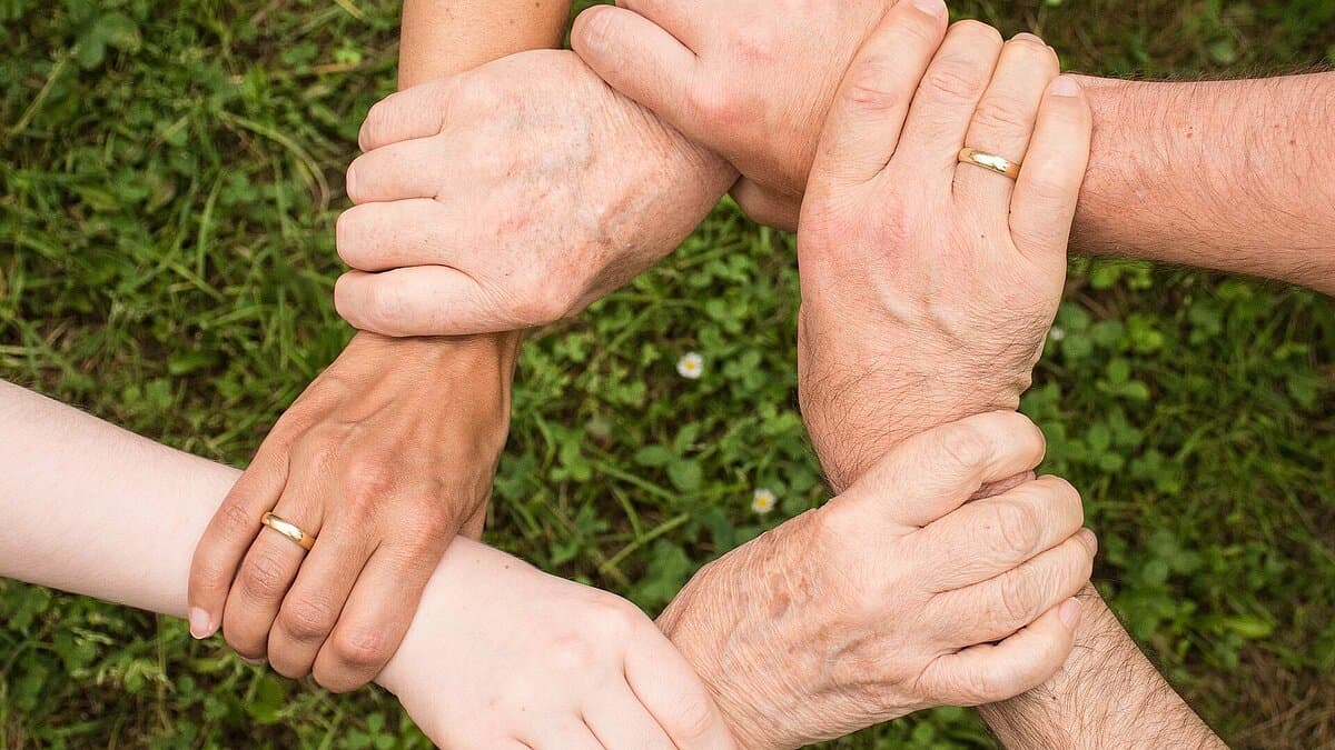 Personen halten sich im Kreis am Handgelenk. © Pixabay