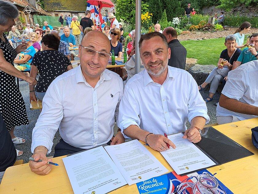 Oberbürgermeister Julian Vonarb und Rabia Berrai, stellvertretender Bürgermeister von Saint Denis, unterschreiben den neuen Städtepartnerschaftsvertrag