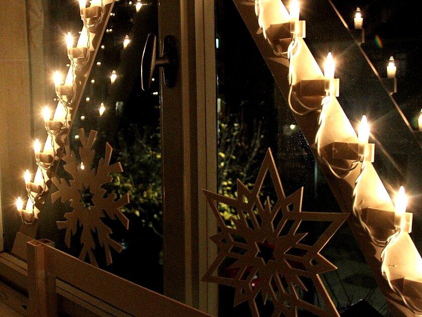 Holzschwibbogen leuchtet am Fenster. © Stadt Gera