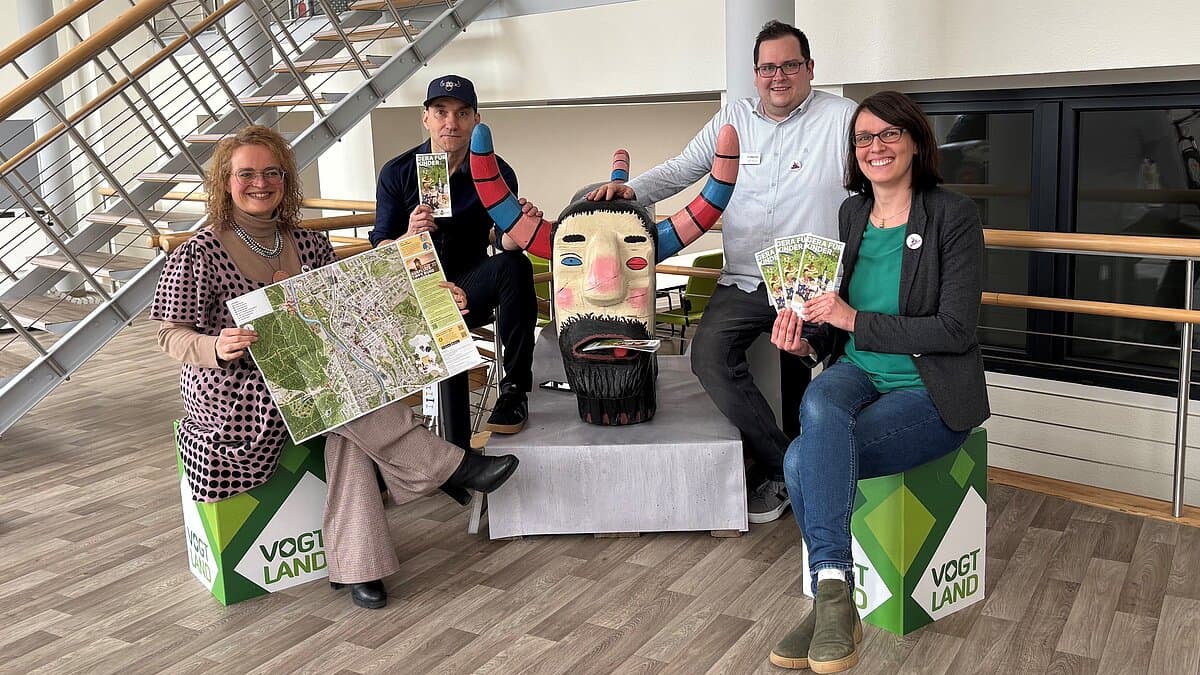 vier Personen halten die ausgefaltete Karte. © GWT