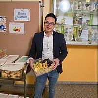 Inhaber Huy Quyen Weber der Firma Obst & Blumen Gera präsentiert eine Schale mit geschnittenem Obst für die Geraer Schulen. © Stadt Gera / Sebastian Schmid