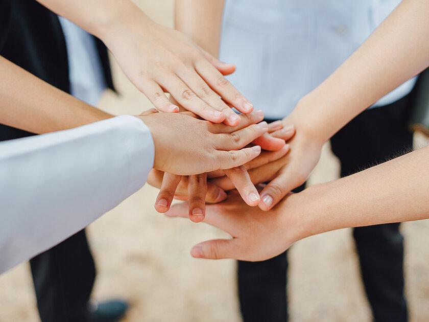 mehrere Hände liegen übereinander. © Adobestock
