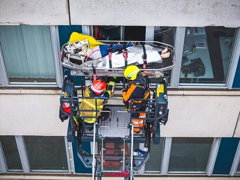Patient wird in einer Trage über eine Drehleiter aus dem Fenster eines Gebäudes transportiert. © Stadt Gera, Amt für Brand- und Katastrophenschutz